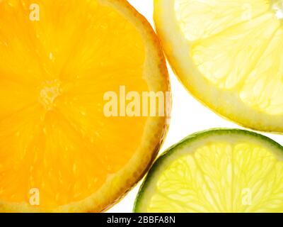 Fettine di limone arancio e lime su fondo bianco Foto Stock