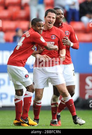 Yann Kermorgant di Charlton Athletic celebra il suo secondo gol con Bradley Pritchard (a sinistra) e Jonathan Obika (a destra) Foto Stock