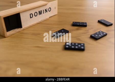 domino set nero con piastrelle in scatola di legno su sfondo di legno Foto Stock