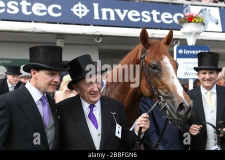 Governatore del mondo allenatore Aidan o'Brien (a sinistra) co proprietari Derrick Smith (seconda a sinistra) e Michael Tabor (a destra) dopo la vittoria nel Derby Investec Foto Stock