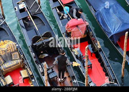 Alto angolo, vista ravvicinata del bellissimo interno di una serie di gondole veneziane tradizionali che vengono pulite da un viaggio Foto Stock