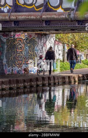 Una giovane passeggiata familiare lungo il fiume Lea a Hackney Wick East London, Regno Unito Foto Stock