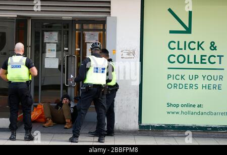 Birmingham, West Midlands, Regno Unito. 31st marzo 2020. Gli agenti di polizia parlano con un uomo seduto in una porta del negozio del centro di Birmingham durante il blocco pandemico di Coronavirus. Credit Darren Staples/Alamy Live News. Foto Stock