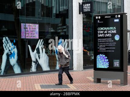 Birmingham, West Midlands, Regno Unito. 31st marzo 2020. Un uomo cammina tra un annuncio NHS e un negozio lussureggiante nel centro di Birmingham durante il blocco pandemico di Coronavirus. Credit Darren Staples/Alamy Live News. Foto Stock