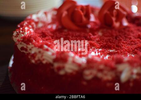 Torta di velluto rosso con rosa fondente sulla parte superiore Foto Stock