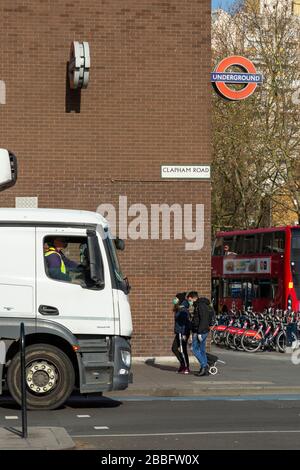 Pedoni su Clapham Road indossando maschere protettive per il viso, durante il blocco di Londra a causa della diffusione di Covid-19. Data di scadenza: 31 marzo 2020 Foto Stock