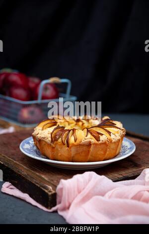 Torta di mele rotonda. Dolci fatti in casa. Cupcake con mele su un tavolo di legno. Cibo semplice. Foto Stock