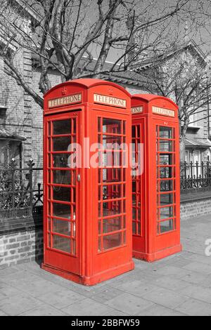 Due cabine telefoniche rosse su sfondo bianco e nero. Il Red Phone Booth è una delle icone più famose di Londra. Foto Stock