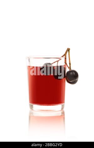 Succo fresco di chokeberry nera matura in vetro e bacche. Aronia beva di bacche. Foto Stock
