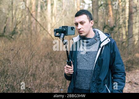 Il turista maschio usa lo stabilizzatore per il telefono e spara la natura Foto Stock