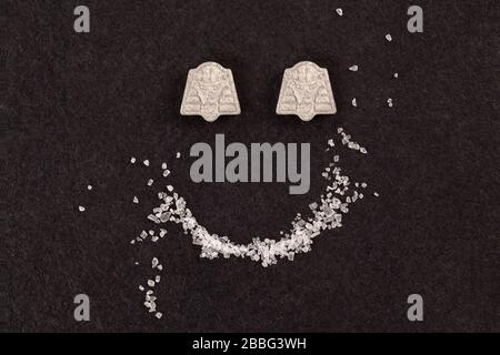 MDMA cristallo ed ecstasy pillole formare faccina sorridente. Foto Stock
