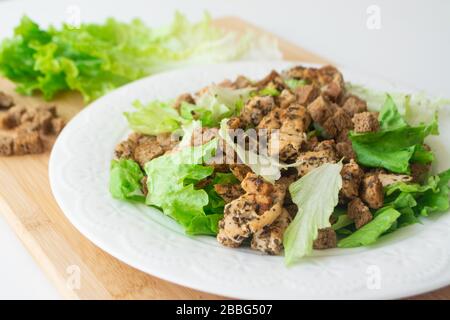 Insalata Caesar classica con i suoi ingredienti: Pollo alla griglia, crostini, lattuga e salsa Foto Stock
