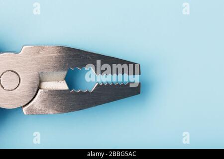 Lo strumento multifunzione multitool si trova su uno sfondo blu. Il concetto di un multi-utensile espanso con spazio libero. Foto Stock