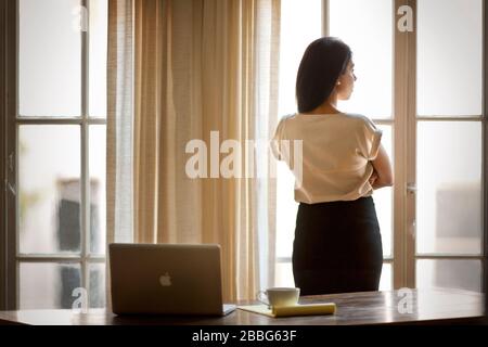 Ritratto di una donna d'affari che guarda fuori una finestra. Foto Stock