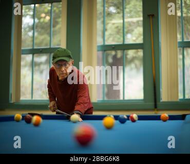 L'uomo anziano attivo ha messo a fuoco su un gioco della piscina. Foto Stock