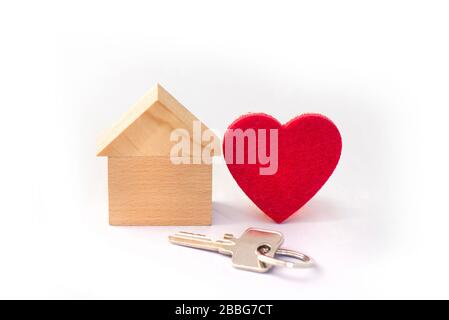 Casa in legno con cuore rosso su sfondo bianco, concetto, simbolo Foto Stock