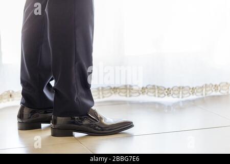Primo piano di scarpe e gambe di un elegante uomo d'affari. Foto Stock