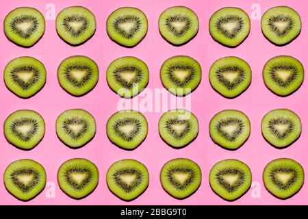 Modello di frutta. Fette di kiwi su sfondo rosa Foto Stock