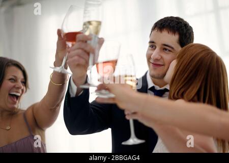 Una sposa felice e sposo festeggiano con un amico al loro ricevimento di nozze Foto Stock