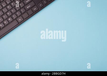 Top sopra primo piano primo piano piatto piano primo piano foto della tastiera nera su sfondo blu con spazio vuoto Foto Stock