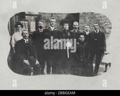 Foto di matrimonio familiare belga d'epoca con notevole abito nero da sposa, e decorato con piume, stimato tra il 1900 e il 1920, Anversa Foto Stock