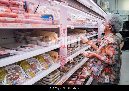 Bangkok, Thailandia - 29 marzo 2020 : asian Senior Old Woman indossare maschera viso igiene scegliere e acquistare carne di maiale fresco nel supermercato a coro Foto Stock