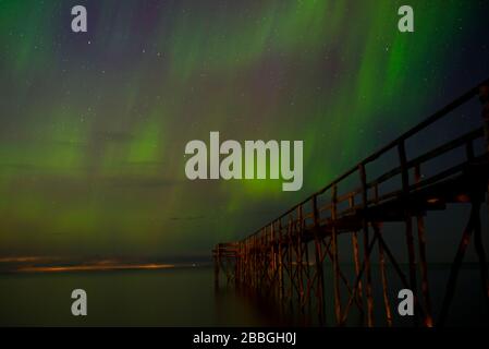 Aurora danzante sul molo di legno del Lago Winnipeg, Manitoba, Canada Foto Stock