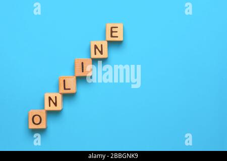 Word Online realizzato con cubi di legno per la stampa letterpressa su sfondo blu. ONLINE scritto su cubi di legno. Concettuale. Espansione del business online. Espansione Foto Stock