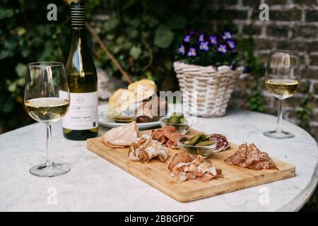 Salumi Wine Garden. Bicchiere di vino. Terrazza esterna, giornata soleggiata, giardino verde Foto Stock