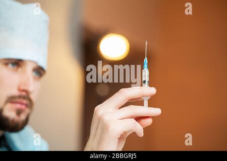 Il medico entra in una soluzione iniettabile in siringa Foto Stock