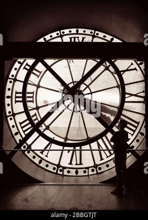 Un turista in cerca thrugh gigantesco orologio torre a Parigi, Francia. Foto Stock