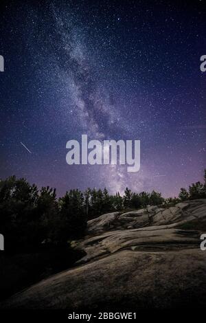 Meteor cade in scena della milkyway sulle rocce nel Parco provinciale della diga di Pinawa manitoba Canada Foto Stock