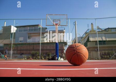 Il basket usato in primo piano si trova su un campo da basket e un basket con uno sfondo sfocato Foto Stock