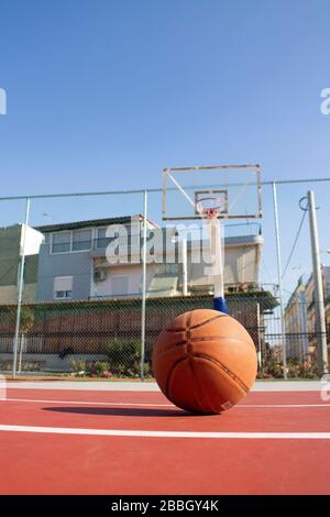 Il basket usato in primo piano si trova su un campo da basket e un basket con uno sfondo sfocato Foto Stock