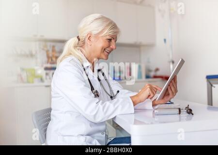 Medico senior femminile nel suo ufficio Foto Stock
