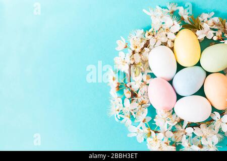Uova di Pasqua e fiori su sfondo blu Foto Stock