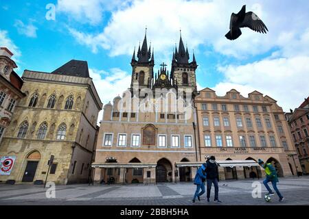 Padre e i suoi figli che indossano maschere facciali giocano a calcio nella deserta Piazza della Città Vecchia di Praga, Repubblica Ceca, 31 marzo 2020. (Foto CTK/Vit Simanek) Foto Stock