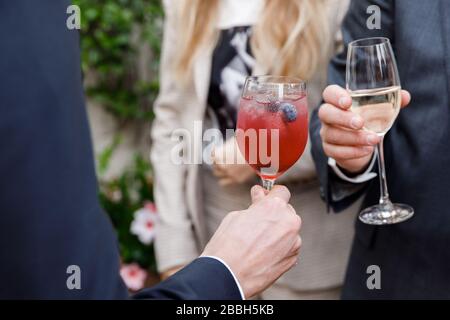 Primo piano orizzontale di uomo caucasico in abito e camicia che tiene un bicchiere alto con vino Foto Stock