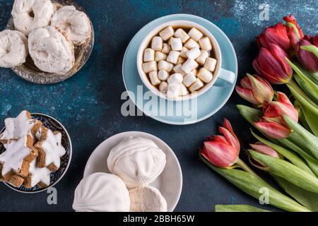 Piatto laici bella primavera tulipano fiori, una tazza di caffè e torte su sfondo rustico in legno. Foto Stock