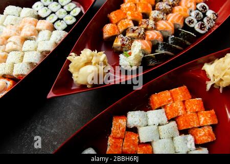 sushi giapponese cibo. Vari tipi di sushi servito su una barca vicino. Grande serie di panini su un piatto in un ristorante. Foto Stock