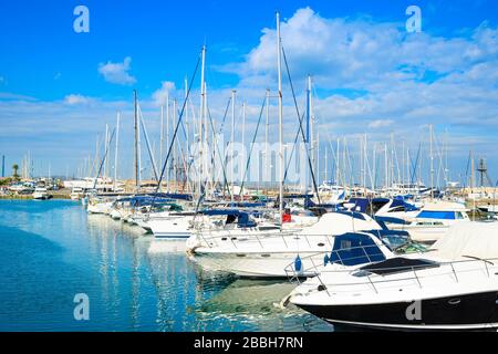 Barche bianche e barche a motore nel porto turistico, riflessione sull'acqua, Larnaca, Cipro Foto Stock