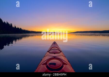 Kayak con kayak rosso sul lago Beaver all'alba, Lake Country, British Columbia, Canada. Foto Stock