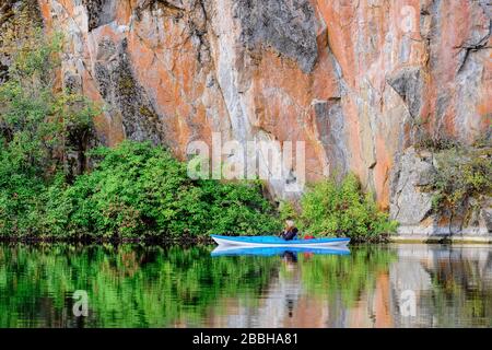 Kayak con kayak blu che guarda le formazioni rocciose sul Lago giallo nella Okangan Valley della British Columbia, Canada. Foto Stock