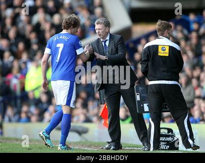 Il manager di Everton David Moyes (centro) saluta Nikica Jelavic quando viene sostituito dal campo Foto Stock