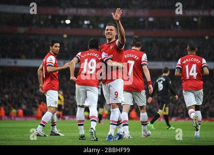 Lukas Podolski dell'Arsenal festeggia dopo aver segnato l'obiettivo di apertura del gioco contro Wigan Athletic. Foto Stock