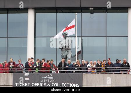 I fan si radunano intorno alla statua di Sir Bobby Moore al di fuori dello stadio di Wembley Foto Stock