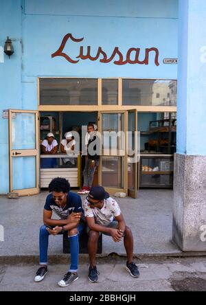 Panetteria e uomini su cellulare, Havana Vieja, Cuba Foto Stock