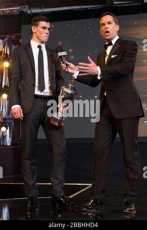 Gareth Bale accetta il premio PFA Young Player of the Year dal presentatore di Sky Sports David Jones durante i PFA Player of the Year Awards 2013 al Grosvenor House Hotel di Londra. Foto Stock