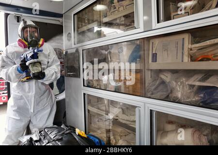 Morrisville, Pennsylvania, Stati Uniti. 31st Mar, 2020. : la prominente azienda di disaster recovery National Restoration si è rapidamente spostata in prima linea contro la pandemia globale offrendo il suo nuovo servizio di disinfezione di coronavirus libero di veicoli di prima risposta in comuni a livello nazionale. Qui, i membri del team fanno un passo in su per disinfettare le automobili della squadra e i camion del fuoco nel reparto di polizia di Morrisville Borough, vicino a Philadelphia 31 marzo 2020 credito: : Sparatutto della stella/punzone di mezzi/notizie dal vivo di Alamy Foto Stock