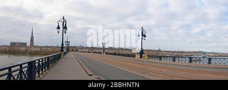 Ampia vista panoramica sul ponte con tram, lampioni stradali e cityline. Giorno invernale nuvoloso. Pont de Pierre, Bordeaux, Francia Foto Stock